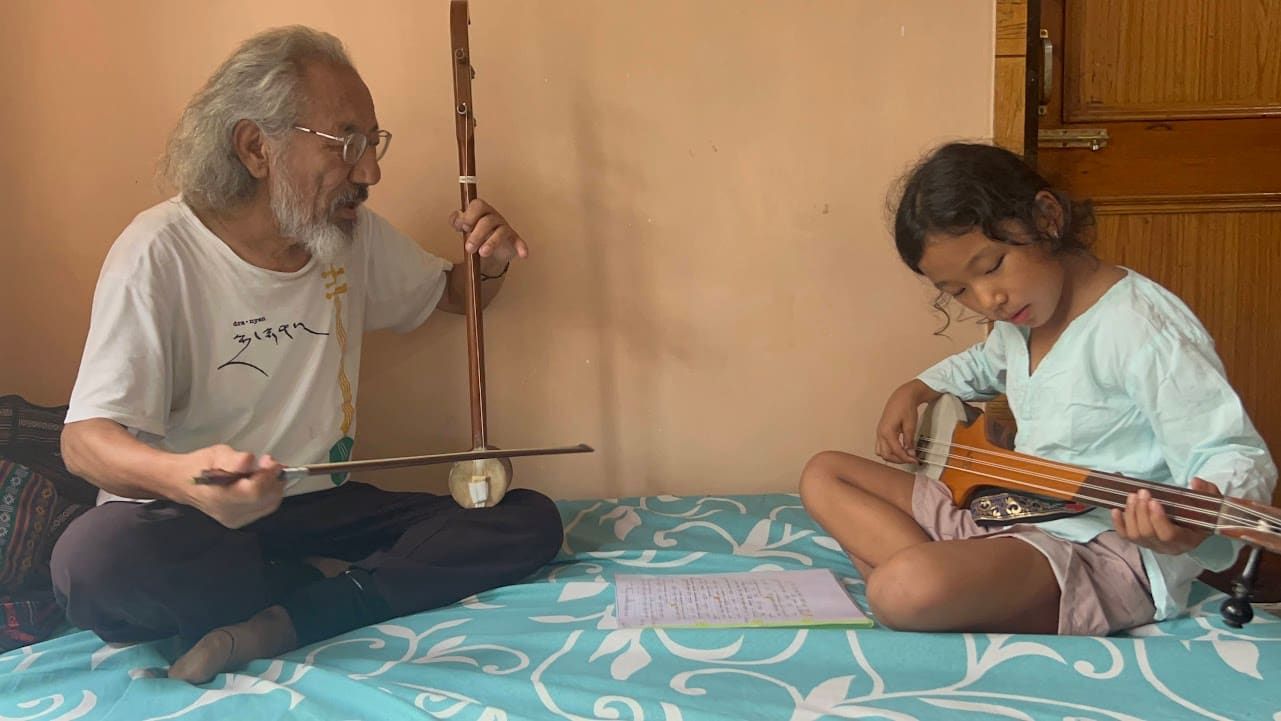 A dramnyen teacher playing for students